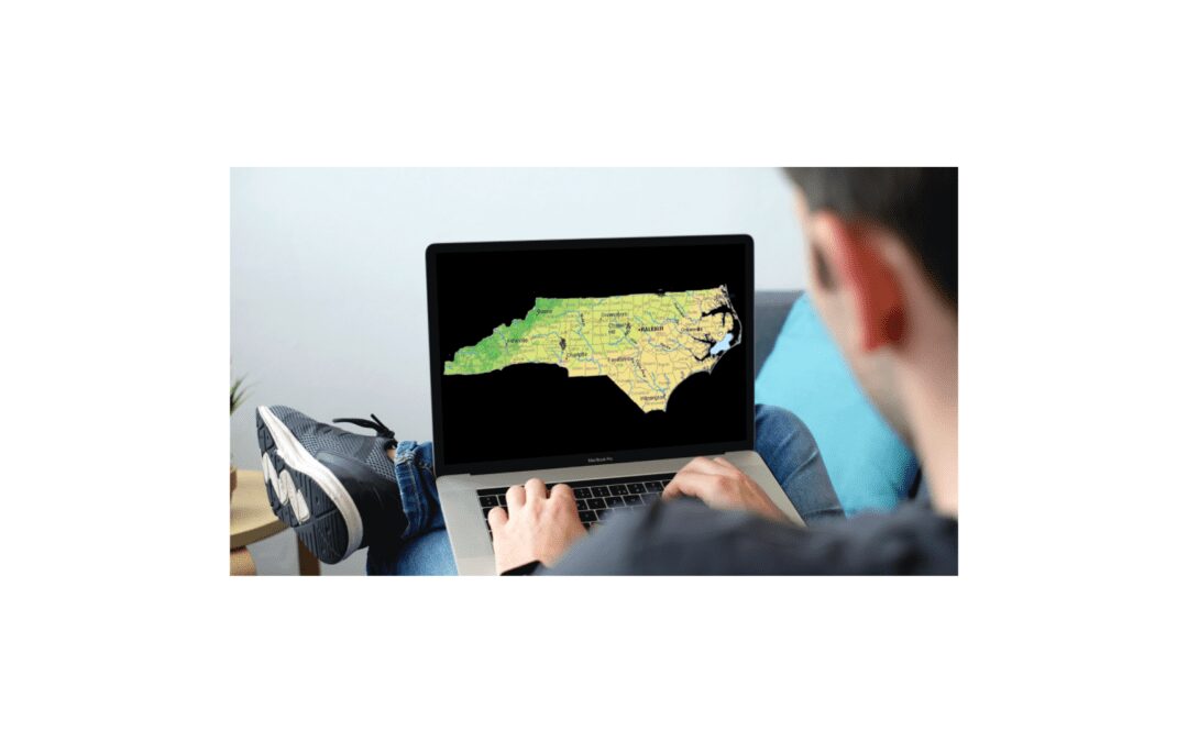 Man on laptop looking at map of North Carolina
